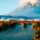 Ancient stone bridge in mist with figures admiring view at golden hour.