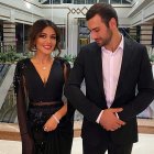 Elegant couple in formal attire in grand hall with glass ceiling