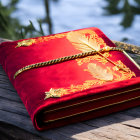 Red Book with Golden Embroidery and Chain on Wooden Surface