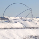 Futuristic dome city in snowy landscape with mountains