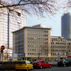 Urban skyline with skyscrapers, cherry blossoms, apartments, and taxis.