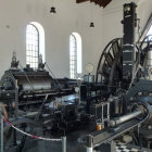 Vintage Steam Engine in Ornate Sunlit Hall with Arched Windows