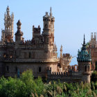 Majestic castle with tall spires in lush green landscape