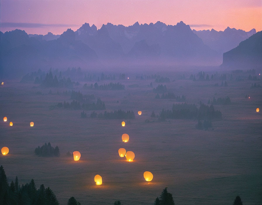 Tranquil dusk landscape with glowing lanterns above misty field & silhouette mountain peaks