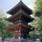 Traditional multi-tiered pagoda in snowy, sunlit sky with petals