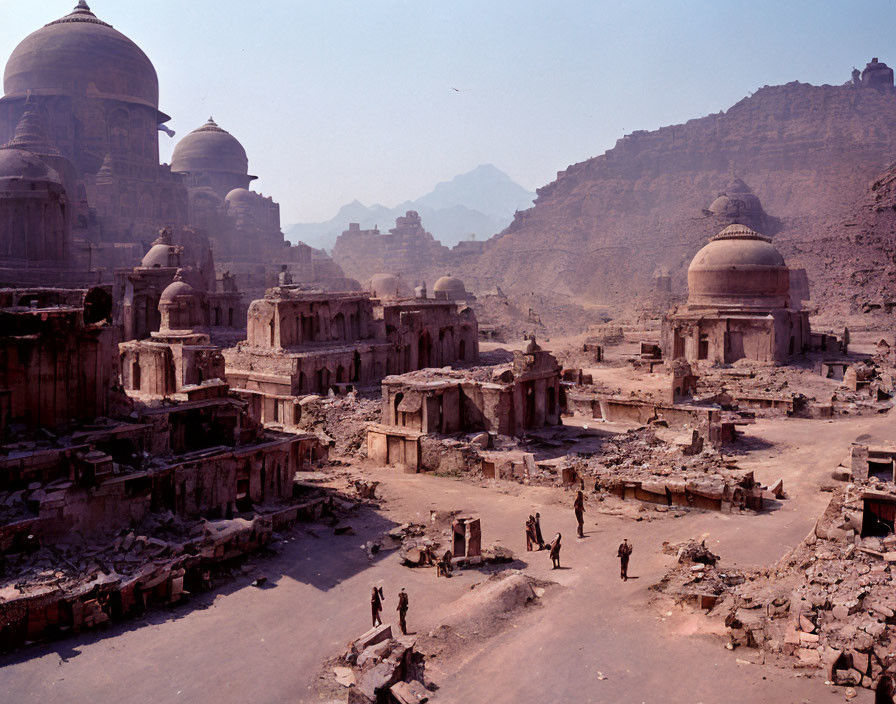 Group of People Walking Among Ancient Ruins and Mountains