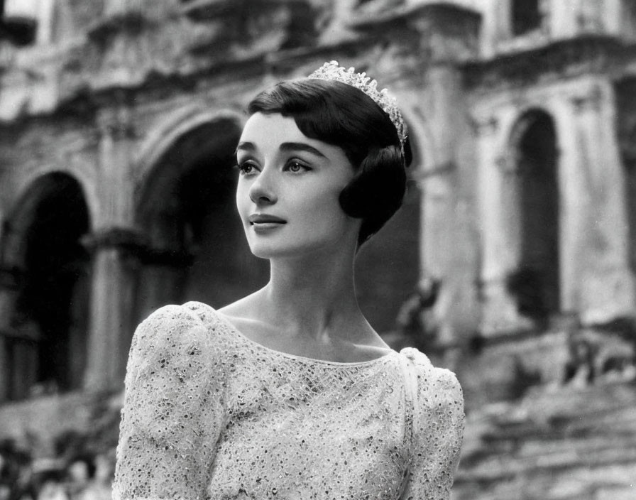 Monochrome image of woman in tiara and elegant dress.