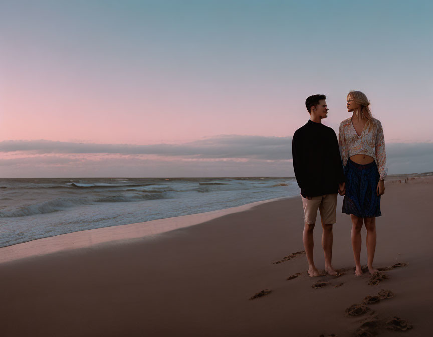 Couple on Beach at Twilight with Pink Sky & Soft Waves