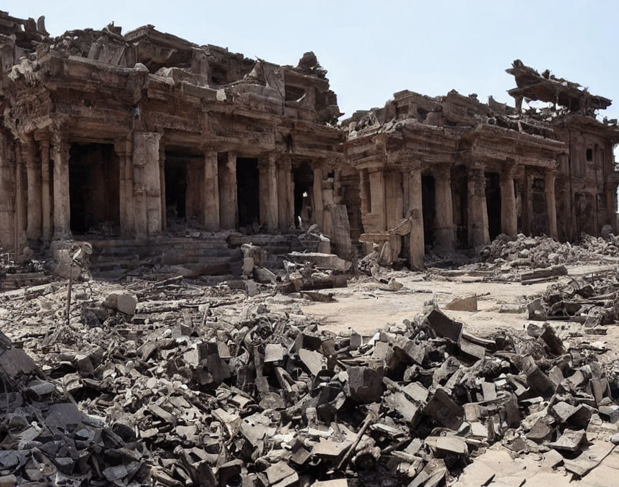 Ancient stone buildings ruins with scattered columns under clear sky