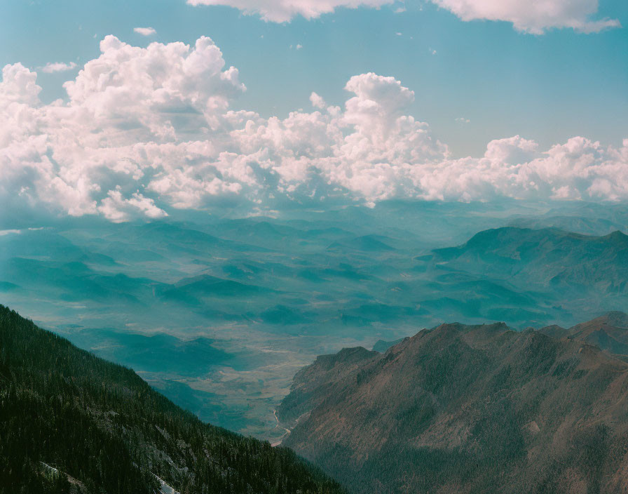 Layered Mountain Ranges Under Vast Blue and Green Sky