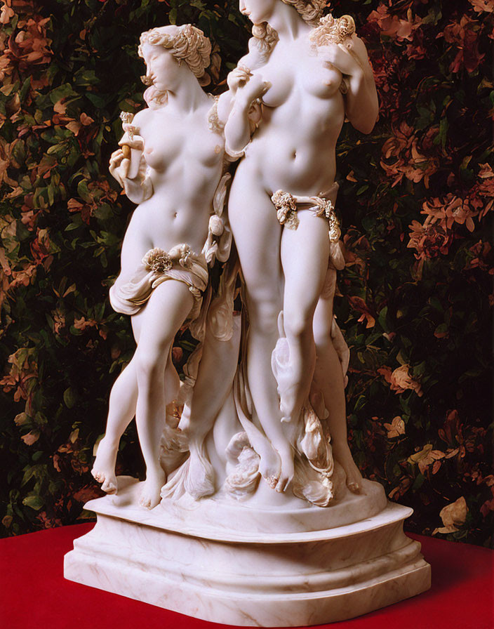 Marble sculpture of intertwined classical figures with floral accents