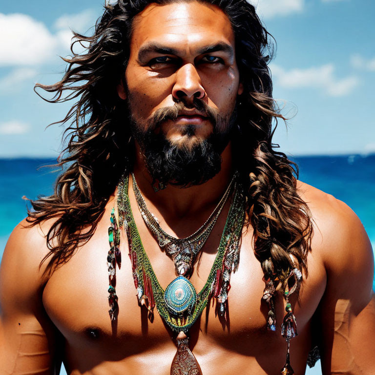 Bearded person with long hair and necklaces gazes intensely against blue sea and sky