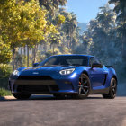 Blue sports car on asphalt road with green trees and clear sky