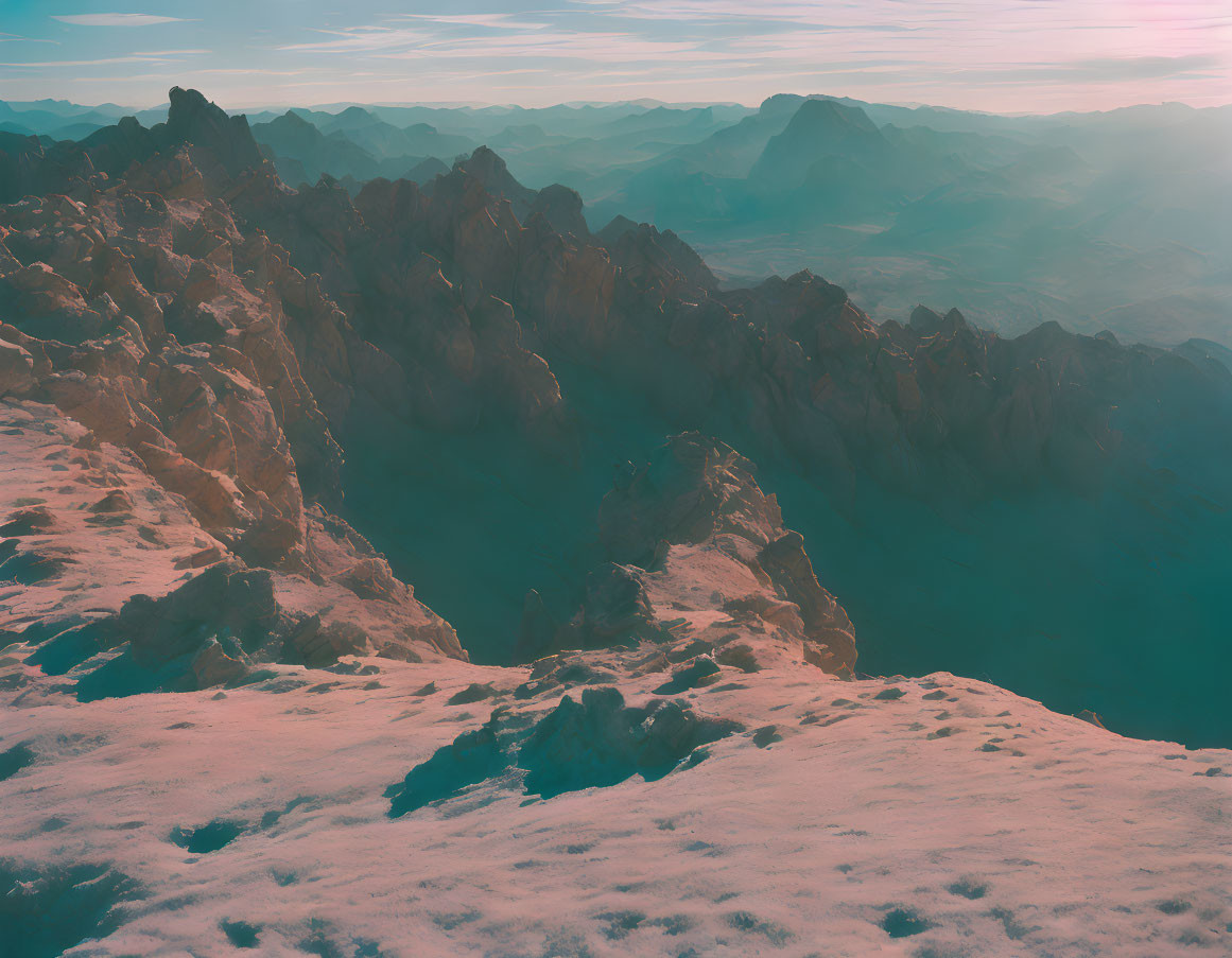 Panoramic view of rugged mountain range under pinkish sky