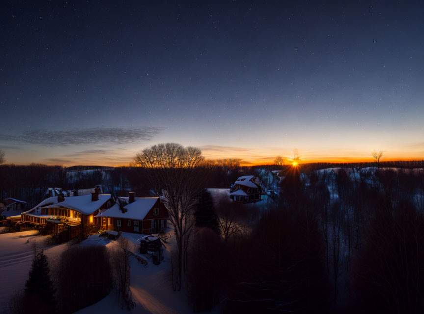 Snow-covered houses under starry sky with warm lights amidst trees