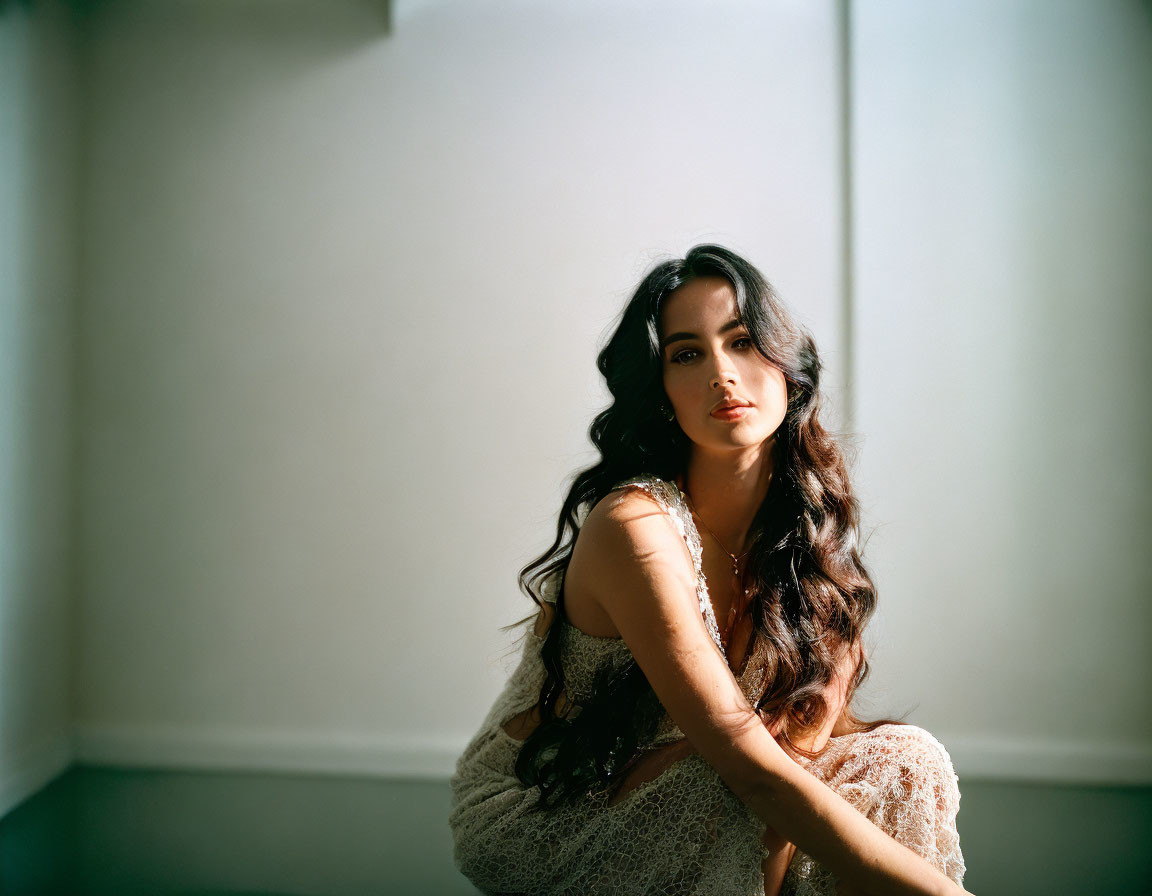 Dark-haired woman sits by window in serene setting