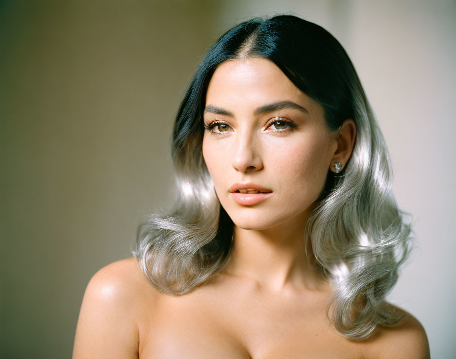 Portrait of woman with ombré hair, diamond earrings, makeup, gazing at camera