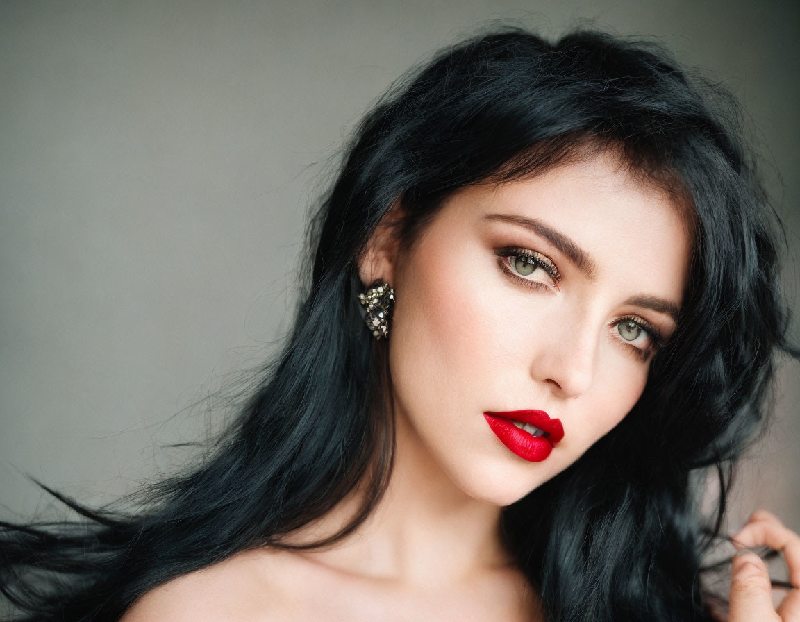 Woman with Black Hair and Blue Eyes in Red Lipstick on Grey Background