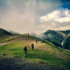 Scenic mountain trail with rolling hills and dramatic clouds