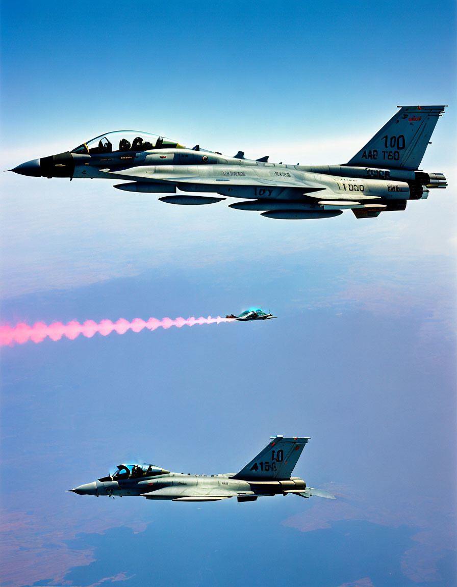 Formation of Three Fighter Jets Emitting Red Smoke Trail in Clear Sky