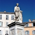 Ornate white building with sculptures and balconies under clear blue sky