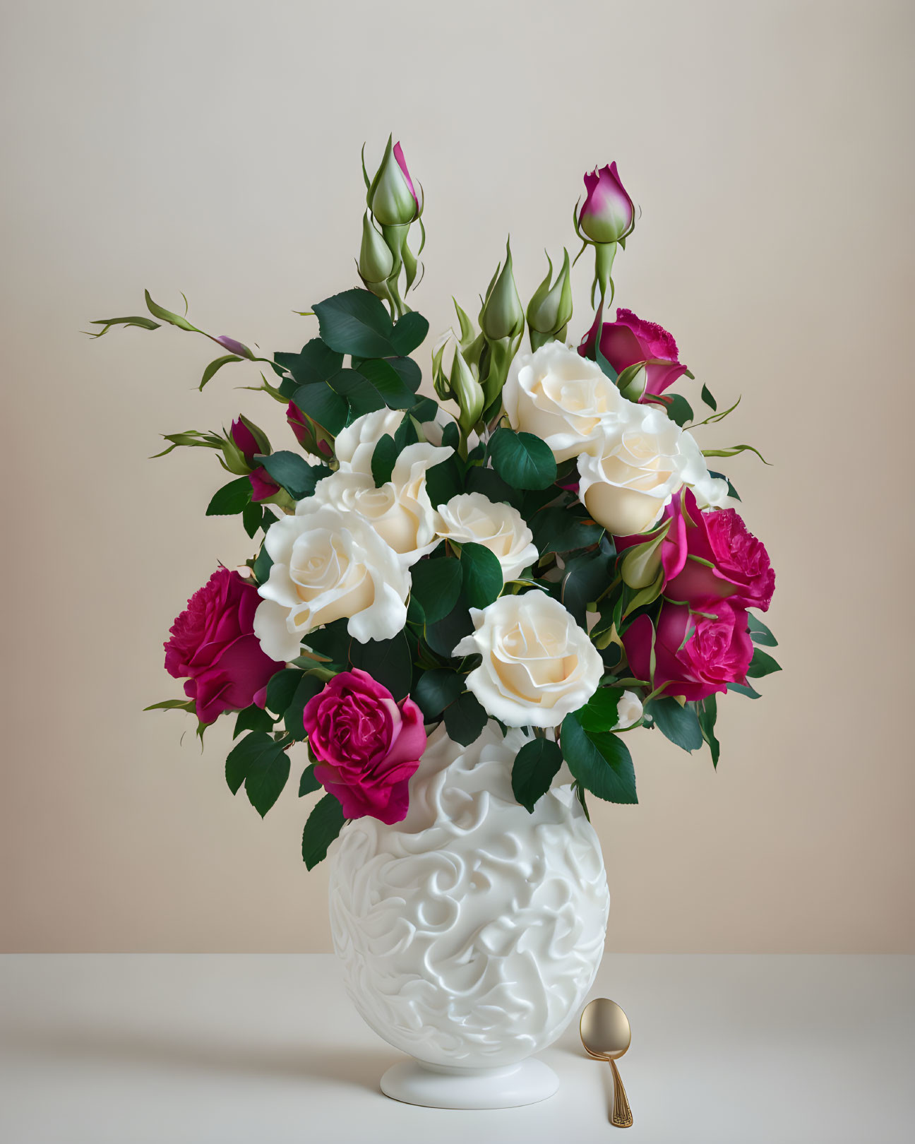 Pink and white rose bouquet in patterned vase with golden spoon on beige background