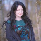 Enigmatic woman with dark hair in mystical forest