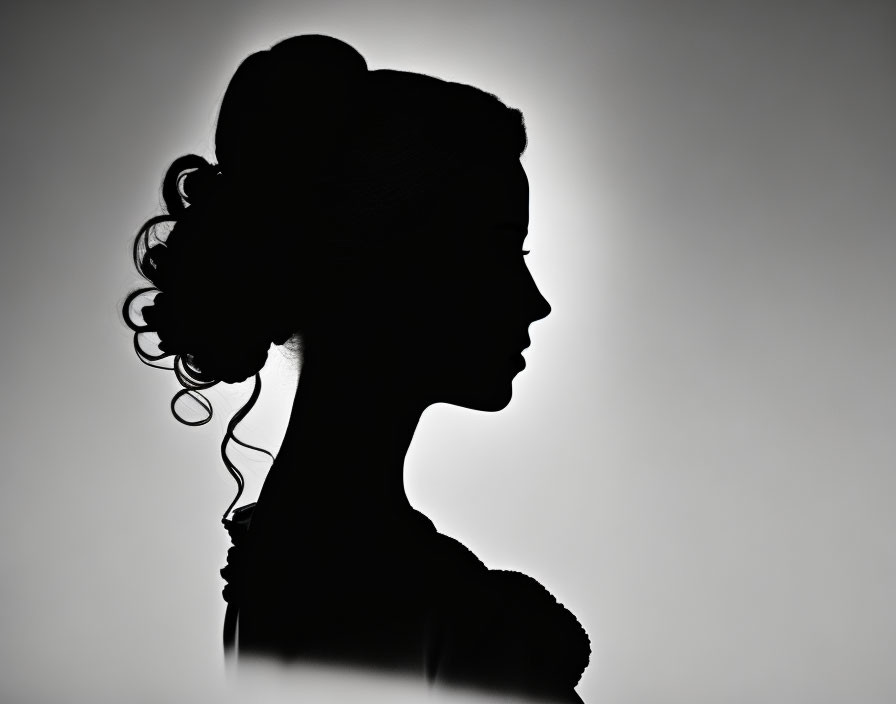 Profile view of woman's silhouette with elegant hairstyle on gradient background
