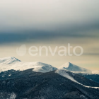 Colorful Stylized Mountains in Surreal Landscape with Geometric Sky and Dark Foliage