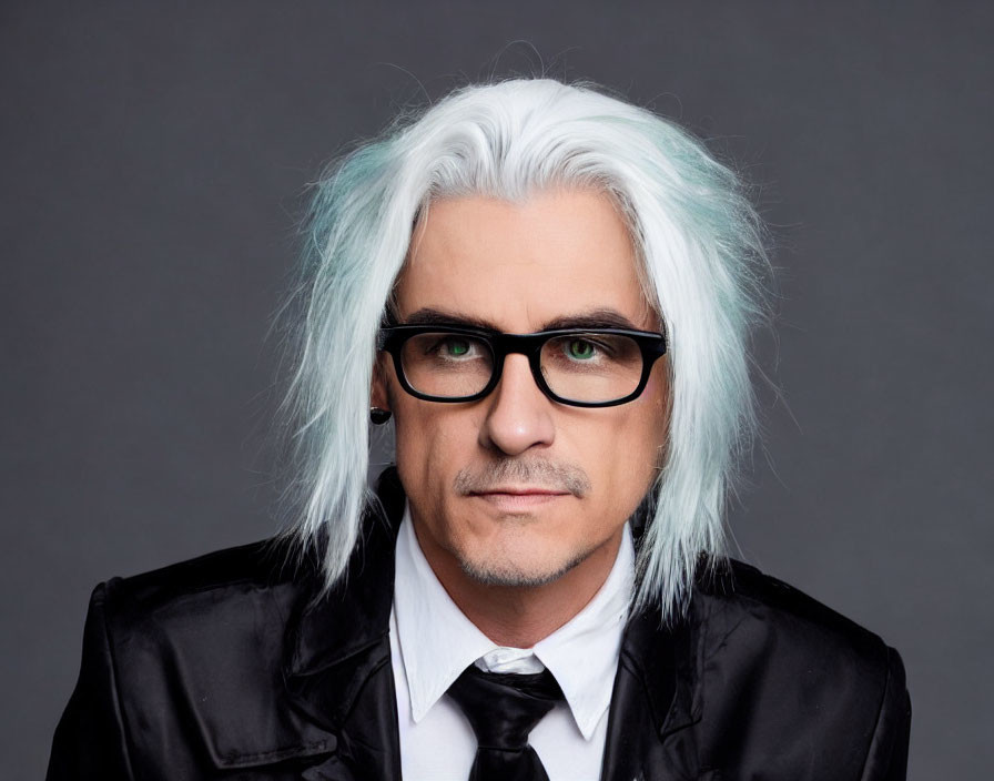 Man with White and Teal Hair in Black Suit on Grey Background