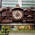 Stylized women and floral motifs mural with ornate clock on building facade