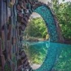 Tranquil river scene with arch bridge, blossoms, stones, and pagoda in lush setting