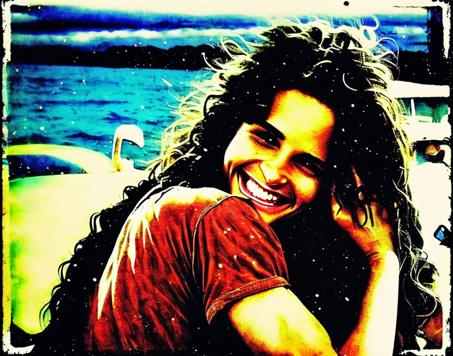 Curly-haired woman laughing by the vibrant sea