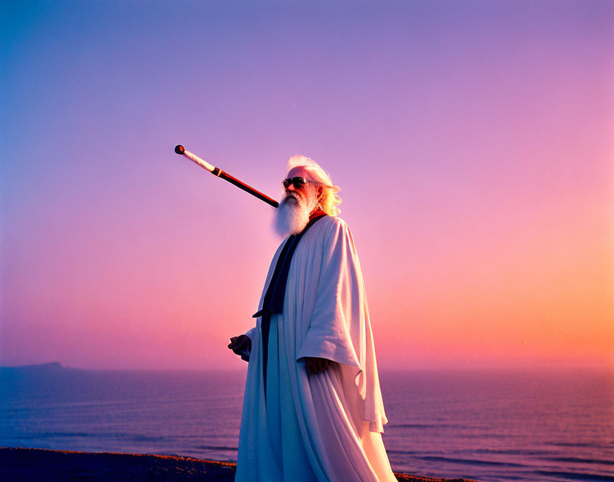 Elderly man with long white beard on beach at sunset