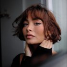 Pensive woman with short curly hair and freckles, raindrops on window