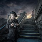 Woman on ornate staircase with book, lamp post, and mystical castle at night