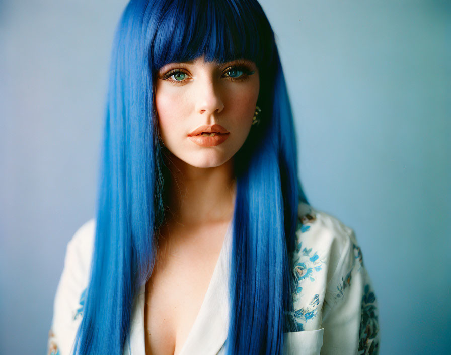 Woman with Blue Hair and Floral Top on Blue Background