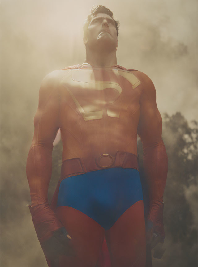 Heroic Figure in Red and Blue Costume Stands Strong Amid Sunlight and Mist