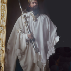 Regal man in crown and cape with scepter next to gold frame