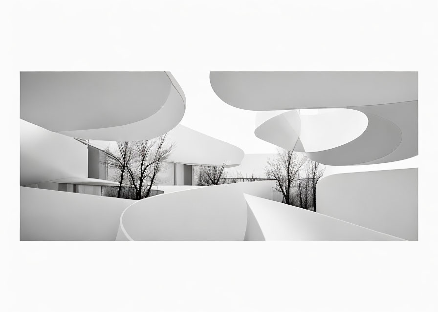 Modern white building with curvilinear structures and leafless trees on a cloudy day