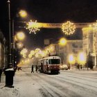 Snowy Night Street Scene with Vintage Tram and Festive Atmosphere