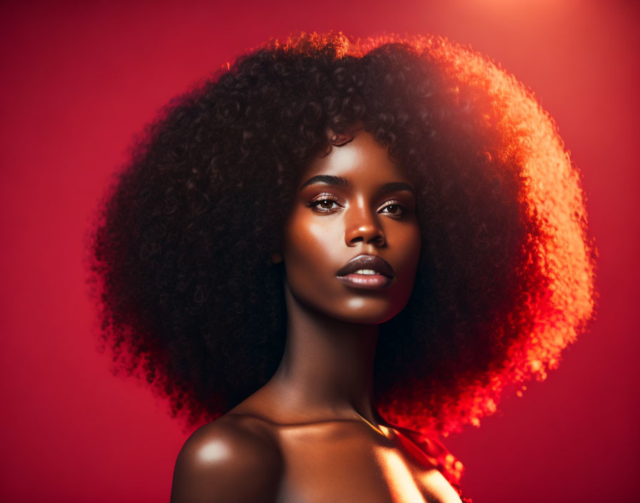 Portrait of woman with voluminous curly hair under red backlight