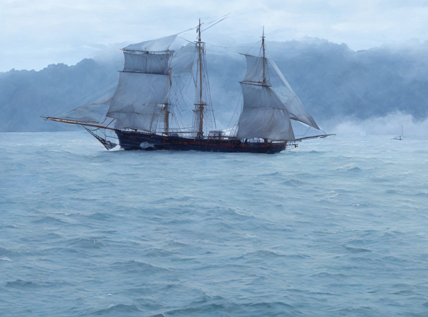 Sailing ship with full sails on choppy sea with misty mountains