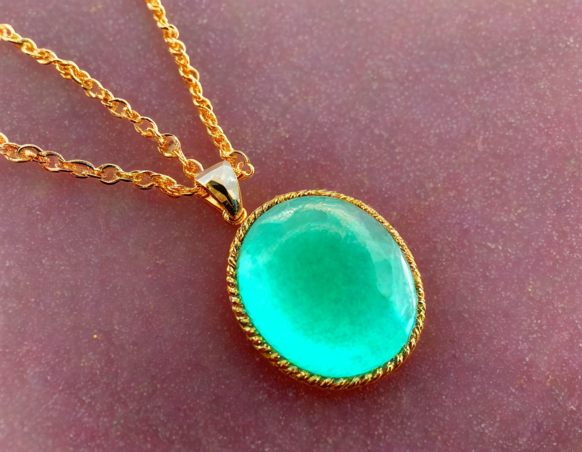 Gold Necklace with Large Oval Turquoise Pendant on Textured Pink Background