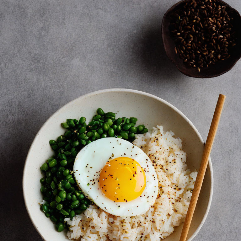 White Rice Bowl with Fried Egg, Green Peas, and Black Sesame Seeds