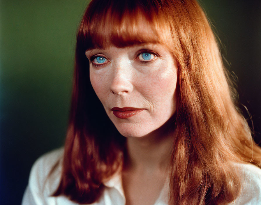 Portrait of woman with red hair, blue eyes, fair skin, and white shirt