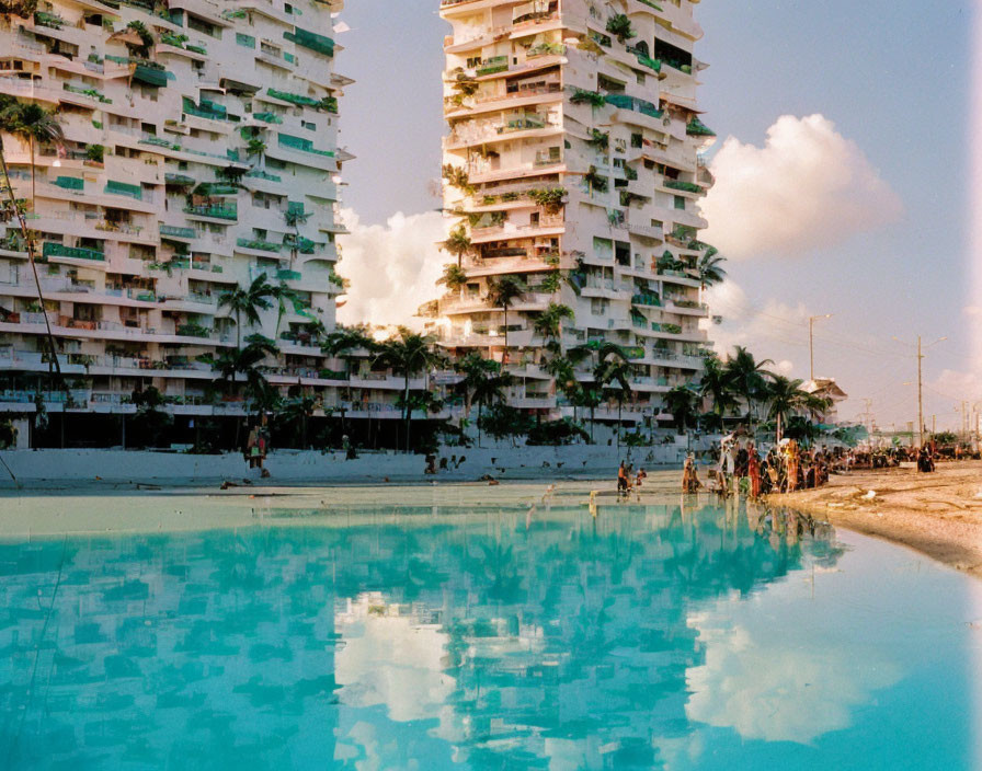 Tranquil pool mirroring sunset sky over beach with buildings