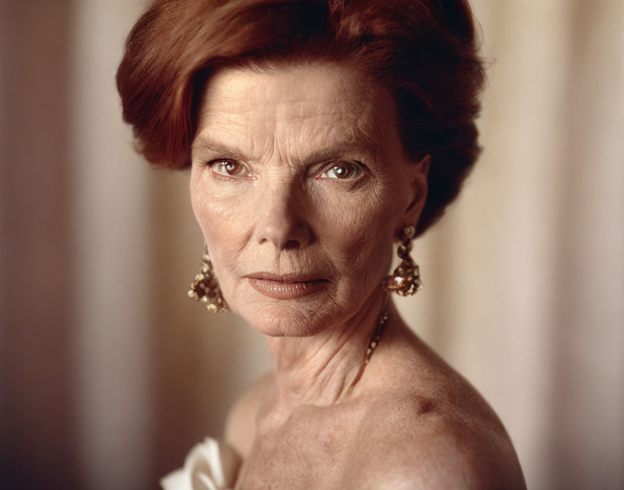 Auburn-Haired Individual in Off-Shoulder White Garment gazes at Camera