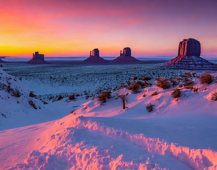 Snow-covered Monument Valley at sunset with pink and purple sky