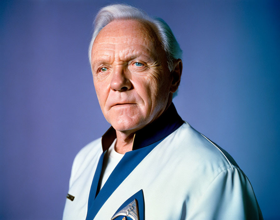 Elderly man in white hair and blue uniform with badge on blue background